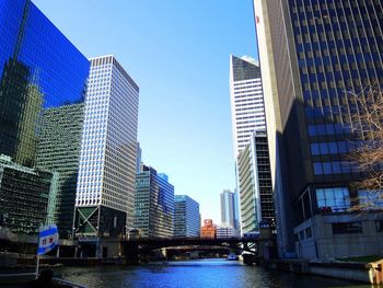 Low angle view of skyscrapers against clear blue sky