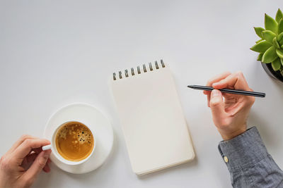 Cropped hand of woman writing in book