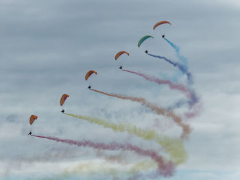 Low angle view of kites flying against sky