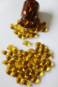 High angle view of yellow bottle on white background