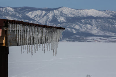 Close-up of frozen lake against mountain range