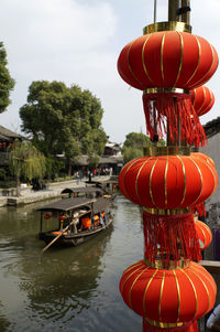 Red lanterns hanging by trees against sky