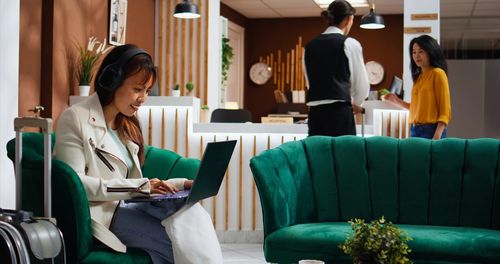 Rear view of woman using laptop at home