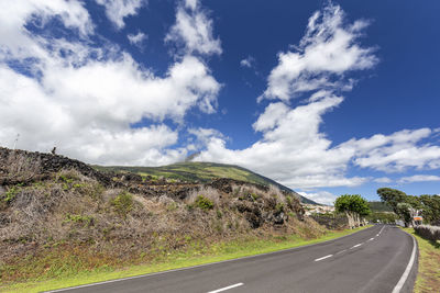 Empty road along landscape against sky