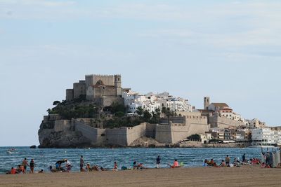 People at beach against sky