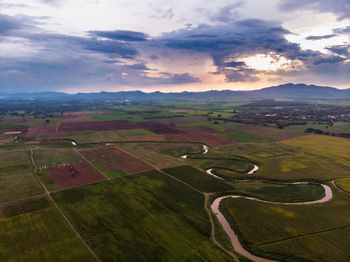 Scenic view of agricultural field against sky during sunset