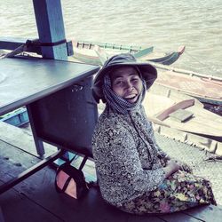 Portrait of young woman sitting on wall