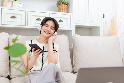 Young woman using digital tablet while sitting at home