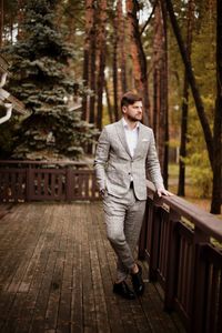 Thoughtful businessman standing against trees