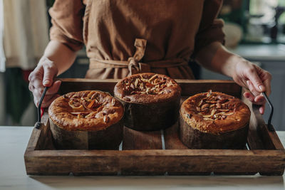 Woman holding tray with freshly baked easter cake in kitchen