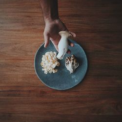 High angle view of hand holding ice cream on table