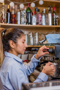 Side view of woman using mobile phone at cafe