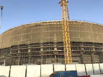 Low angle view of construction site against clear blue sky