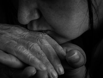 Cropped image of woman kissing parent hand