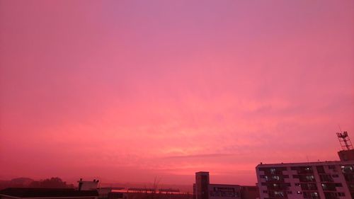 Buildings against dramatic sky during sunset