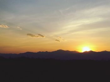 Scenic view of silhouette mountains against sky at sunset