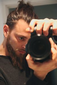 Young man photographing through digital camera