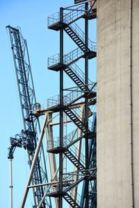 Low angle view of crane against clear blue sky