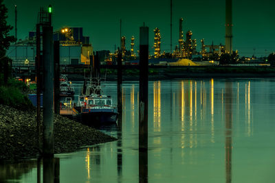 Illuminated pier at harbor against sky at night