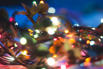 Low angle view of illuminated lighting equipment at night