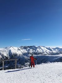 Rear view of snowcapped mountain against clear blue sky