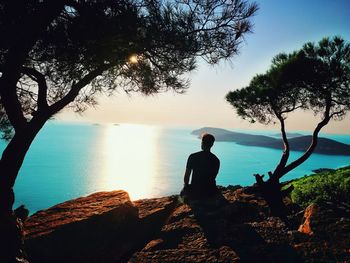 Rear view of silhouette man looking at sea against sky