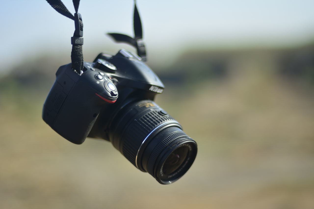 focus on foreground, close-up, technology, metal, photography themes, camera - photographic equipment, selective focus, single object, equipment, low angle view, retro styled, day, metallic, old-fashioned, part of, no people, man made object, outdoors, digital camera, black color