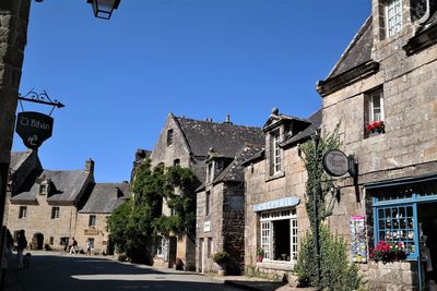 Low angle view of buildings against clear blue sky