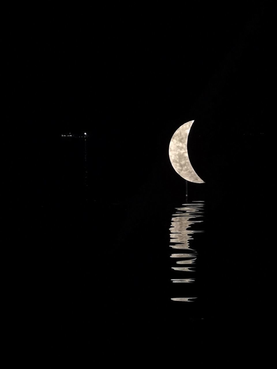 REFLECTION OF MOON IN LAKE AGAINST SKY IN CITY AT NIGHT