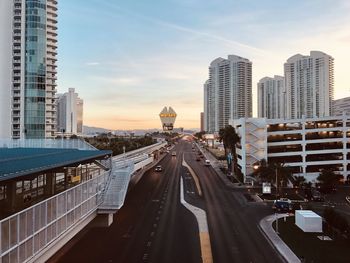 Road amidst buildings in city against sky