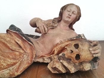 Close-up of human skull on table against white background