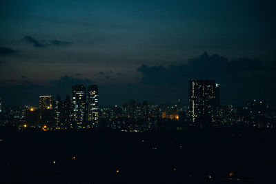 Illuminated buildings against sky at night