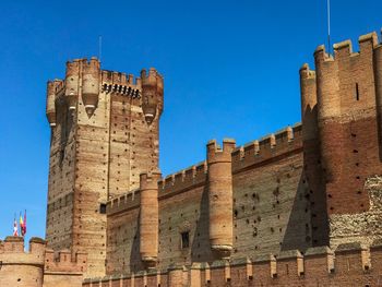 Low angle view of historic building against blue sky