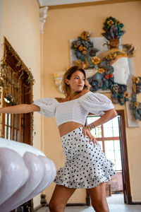 Woman standing against wall at home