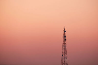 Low angle view of communications tower against sky during sunset