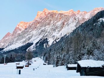 Snow covered land and mountains against sky
