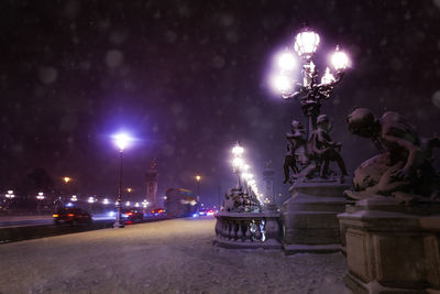 Statue of illuminated street at night