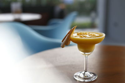 Close-up of refreshing mango smoothie served on a cocktail glass at a bar