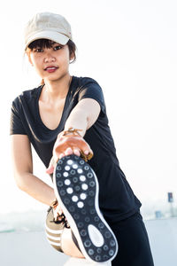 Woman exercising against sky