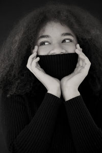 Low angle view of young woman standing against wall