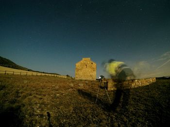 Scenic view of field against clear sky at night