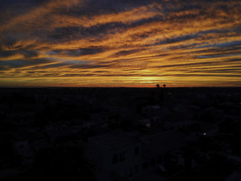 Silhouette buildings against sky during sunset