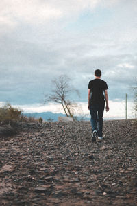 Rear view of man walking on field