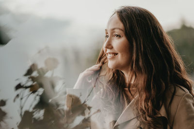 Smiling woman looking away seen through window