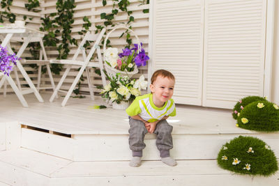 Portrait of cute boy sitting on floor