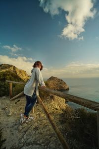 Women standing on wood fence looking in camera 