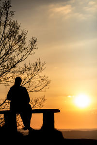 Silhouette man looking at sunset