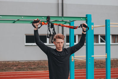 Rear view of man exercising in playground