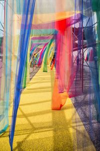Blurred motion of people walking in multi colored umbrella