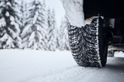 Close-up view of tire of car on snow covered and icy road. themes safety and driving in winter.